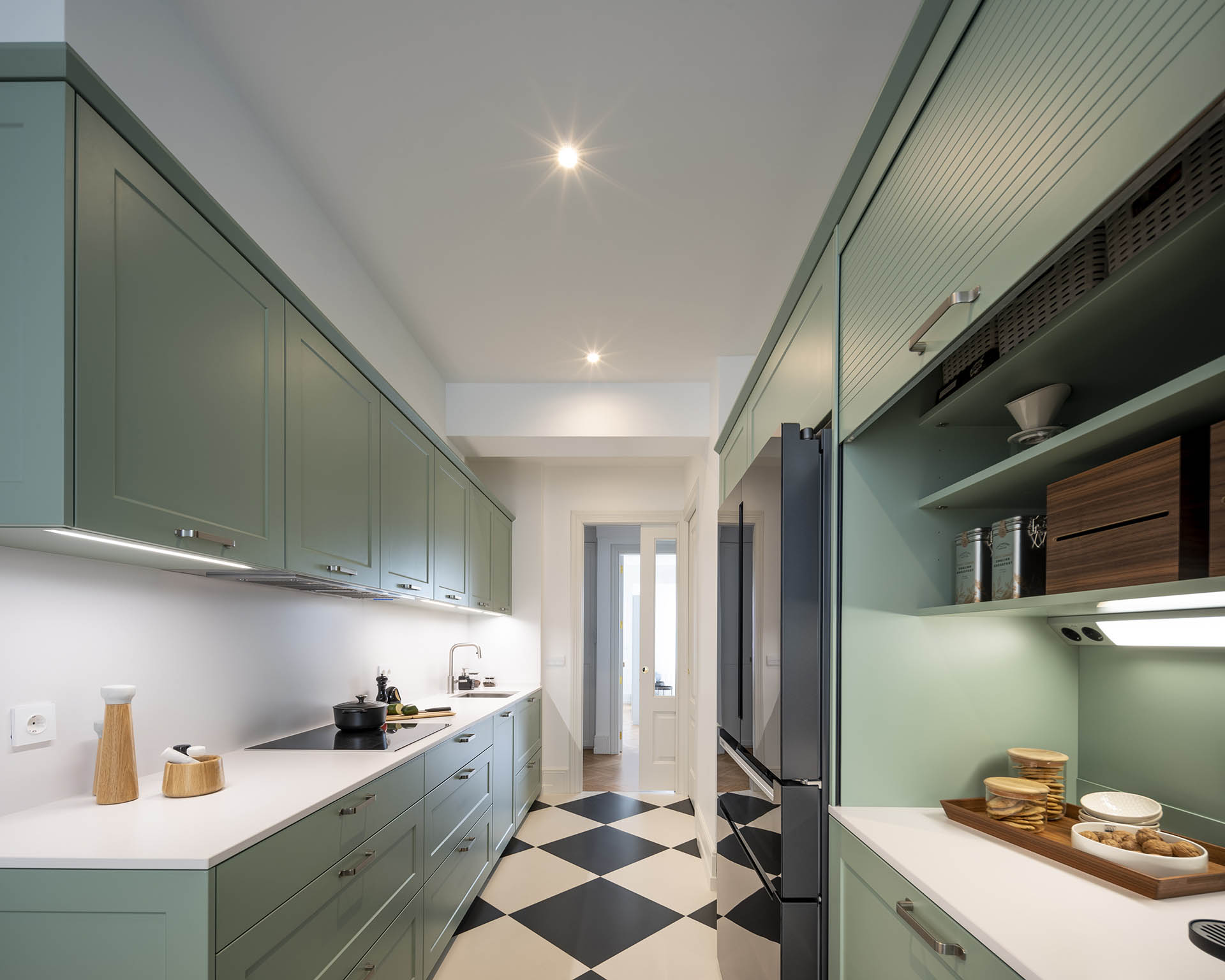 Distribución en paralelo en la cocina verde clásica diseñada por Santos en Santiago Interiores