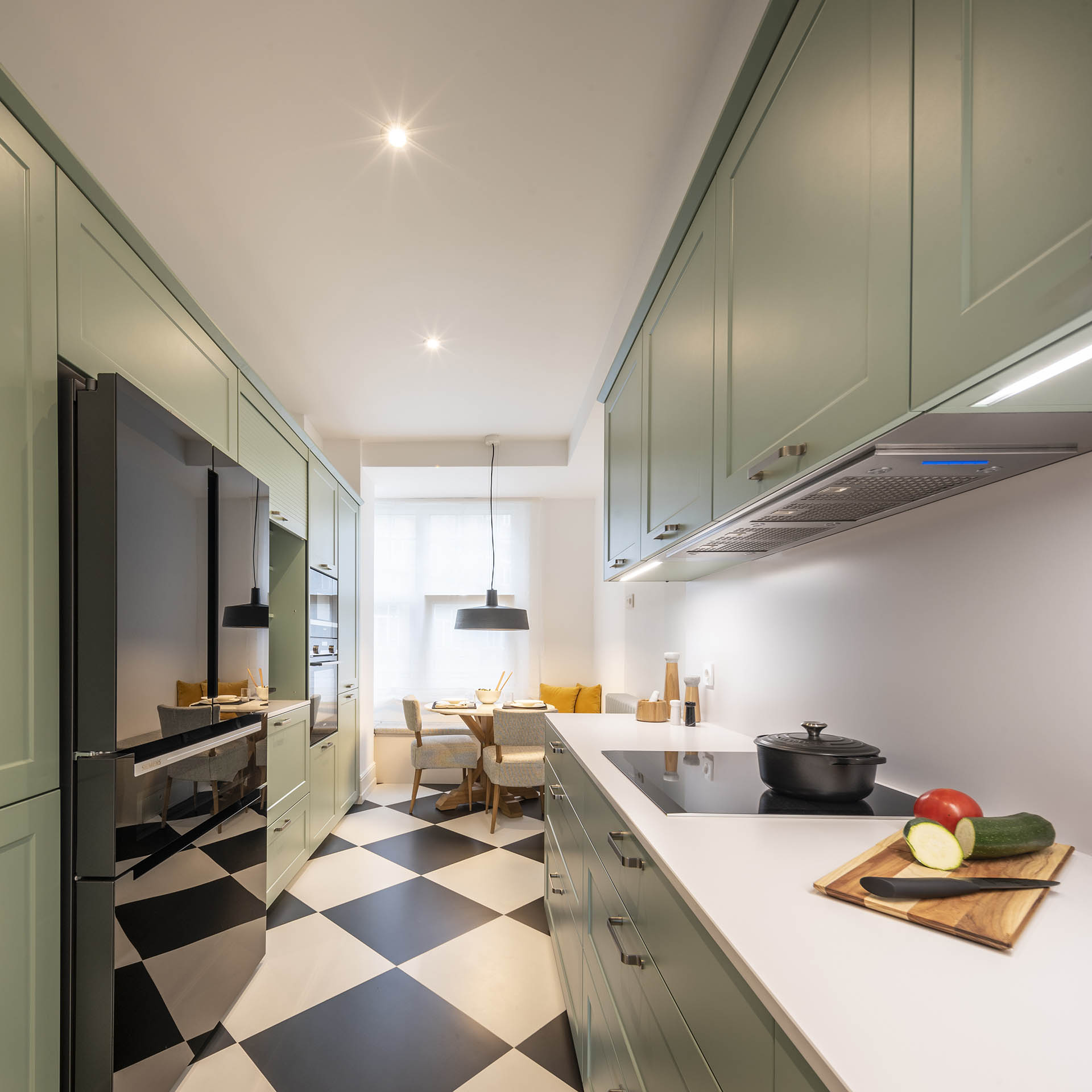 Armarios de apertura lateral en la cocina verde clásica diseñada por Santos en Santiago Interiores